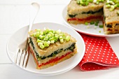 Potato cake with layers of spinach & peppers, spring onions