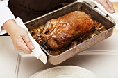 Roast duck in roasting tray, elevated view