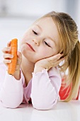 Kleines Mädchen hält eine Karotte