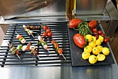 Kebabs on a grill rack and vegetables