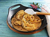 Rabbit legs with pepper sauce in frying pan