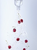Water and cherries pouring out of bottle