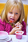 Kleines Mädchen isst Fruchtzwerg