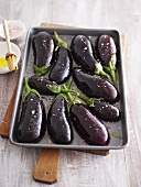 Seasoned aubergine halves on baking tray