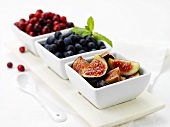 Figs, blueberries and cranberries in dishes