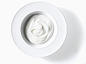 Natural yoghurt on white plate (overhead view)