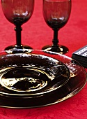 Place-setting with black glass plates and white glasses