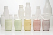 Jars of different yoghurts in front of plastic bottles