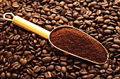 Scoop of ground coffee on coffee beans