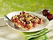 Piece of plum cake with flaked almonds on plate
