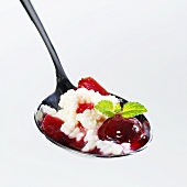 Rice pudding with plum compote on spoon