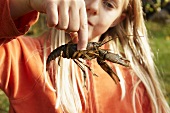Blond girl holding freshwater crayfish