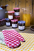 Oven mitts and jars of home-made jam