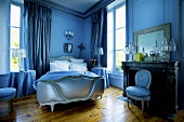 Schlafzimmer in Blau mit Doppelbett & Kamin im Schloss La Verrerie (Frankreich)