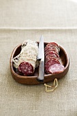 Saucissons in wooden dish with knife