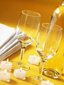 Wine glasses and tealights on yellow background