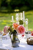 Rosenstrauss am gedeckten Tisch im Garten
