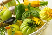 Green tomatoes, courgettes with flowers, peppers in basket
