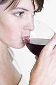 Young woman drinking a glass of red wine