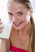 Young woman drinking a glass of milk