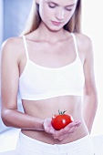 Young woman holding a tomato