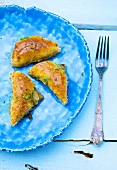 Three pieces of baklava on blue plate
