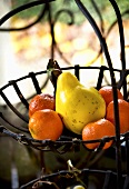 Clementines and quince in wire basket