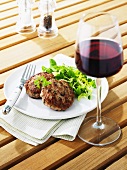 Grilled burgers with corn salad, glass of red wine