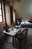 Rustikales Schlafzimmer im Schlosshotel mit Bett & Schreibtisch mit Schreibutensilien