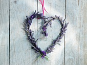 Heart-shaped lavender wreath hanging on a wooden wall