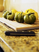 Green and yellow tomatoes on chopping board