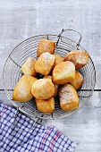 Doughnuts with icing sugar in wire basket