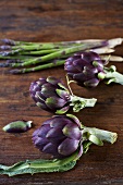 Artichokes and green asparagus on wooden background