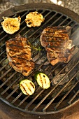 Pork chops, garlic and courgettes on barbecue