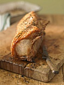 Roast rack of suckling pig on wooden board