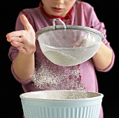 Girl sieving flour