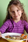 Girl eating vegetable soup