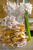 Dusting faworki (Polish fried pastries) with icing sugar