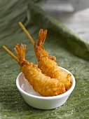 Coconut-coated prawns in a small dish on a banana leaf