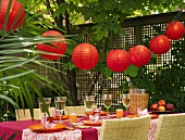 Festive table with white wine & Chinese lanterns out of doors