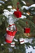 Roter Becher mit Pecannusspralinen hängt am Weihnachtsbaum
