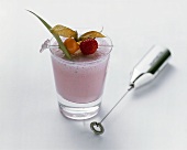 Strawberry shake with fruit on cocktail stick, mini-whisk