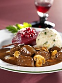 Venison ragout with mushrooms, dumpling and red wine pear