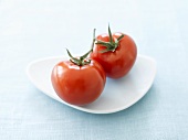 Two tomatoes on a white plate