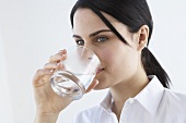 Junge Frau trinkt ein Glas Mineralwasser