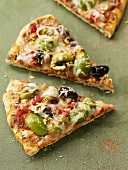 Pieces of pizza topped with olives