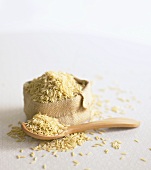 Wholegrain basmati rice on wooden spoon and in small sack