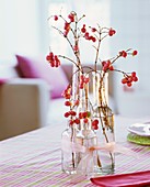 Snowberry twigs in small glass bottles