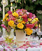 Vase of roses, snapdragons and fennel, windlights