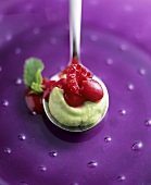 Avocado and raspberry dessert on spoon